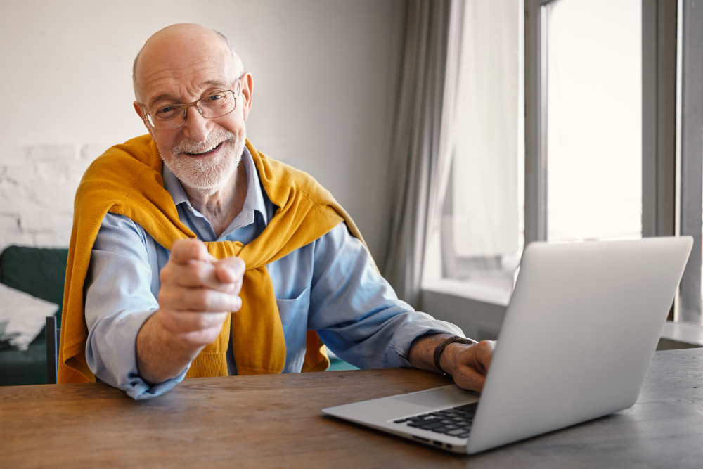 Man at his laptop pointing at you